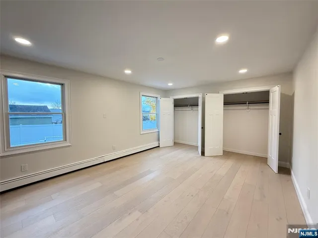 an empty room with closet and windows