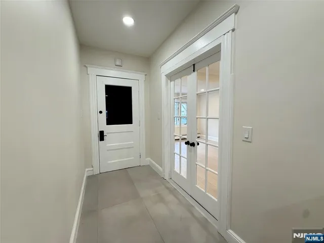 a view of a hallway with wooden floor and a bathroom