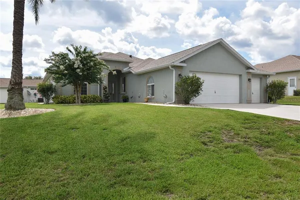 a view of a house with a yard and pathway