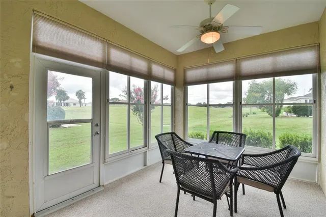 a view of a dining room with furniture large windows and wooden floor