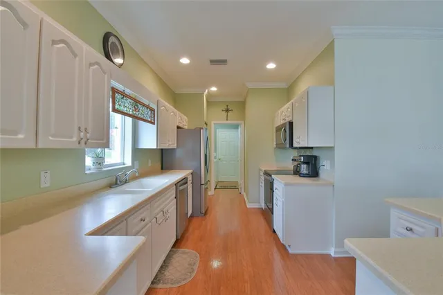 a large kitchen with stainless steel appliances kitchen island granite countertop a sink and cabinets