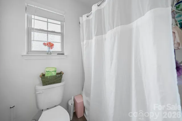 a bathroom with a toilet and a window