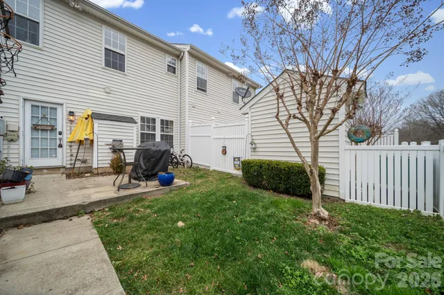 a view of a backyard with chairs and a tree