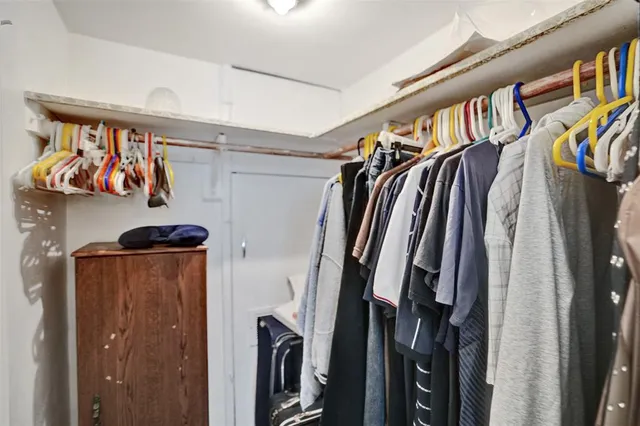 a view of walk in closet with clothes and shoes