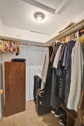 a view of walk in closet with clothes and shoes