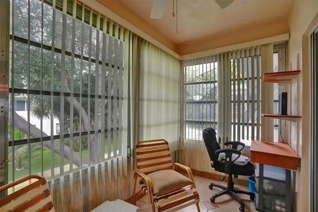 a balcony with chairs and a potted plant