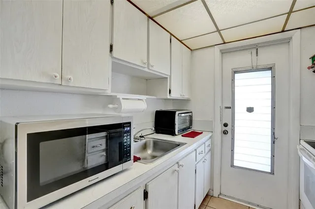 a kitchen with white cabinets and a stove with dishwasher
