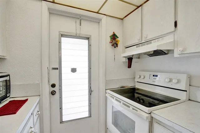 a kitchen with white cabinets and white appliances