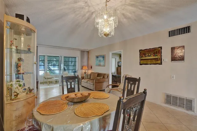 a view of a dining room with furniture a chandelier and wooden floor