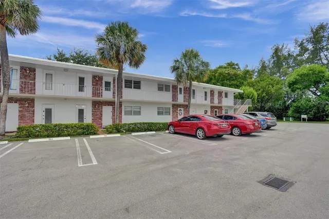 a front view of a house with a garden and parking