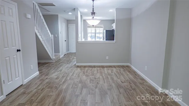 a view of a room with wooden floors and staircase