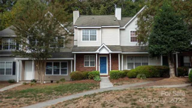 a front view of a house with a yard and potted plants