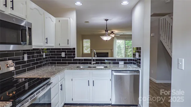 a kitchen with stainless steel appliances granite countertop a sink stove and microwave