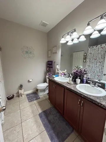 a bathroom with a double vanity sink mirror and toilet