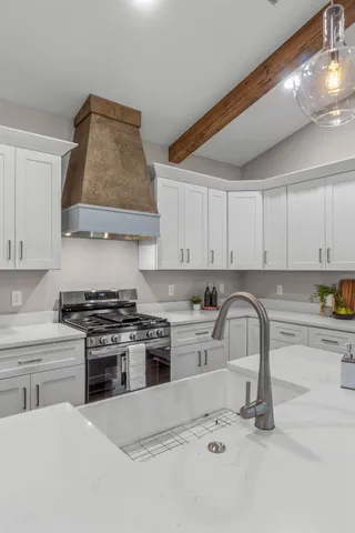 a kitchen with stainless steel appliances a stove a sink and a refrigerator