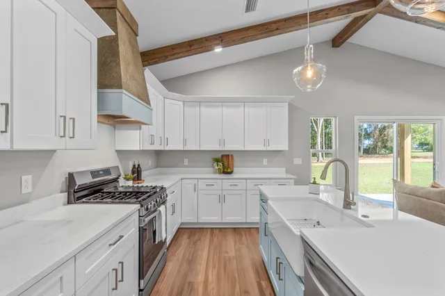 a kitchen with granite countertop a sink stainless steel appliances and cabinets