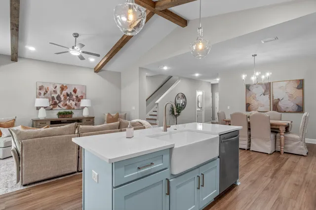 a view of kitchen island a sink and a chandelier