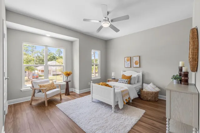 a bedroom with a bed and wooden floor