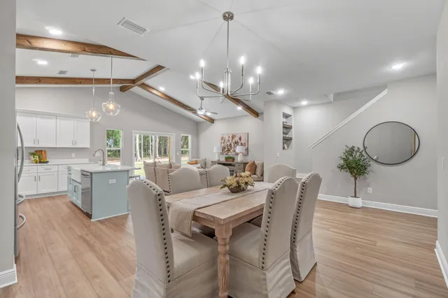 a view of a dining room with furniture wooden floor and chandelier