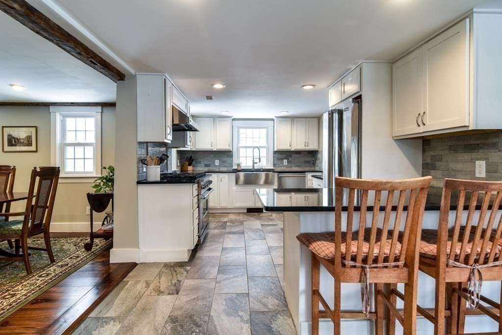 85 Walpole Street Dover, MA 02030 - Photo 11 of 39 a kitchen with stainless steel appliances kitchen island granite countertop a refrigerator and microwave