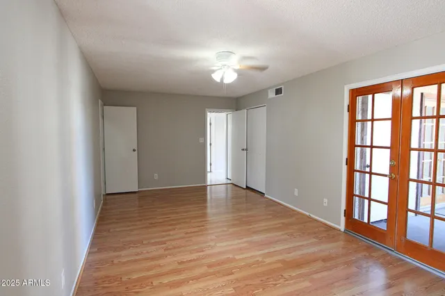 a view of an empty room with window and wooden floor
