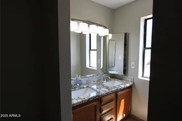 a bathroom with a granite countertop sink and a mirror