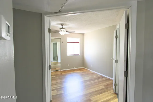 a view of a room with wooden floor and a bathroom