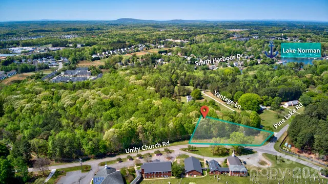 an aerial view of residential houses with outdoor space and trees