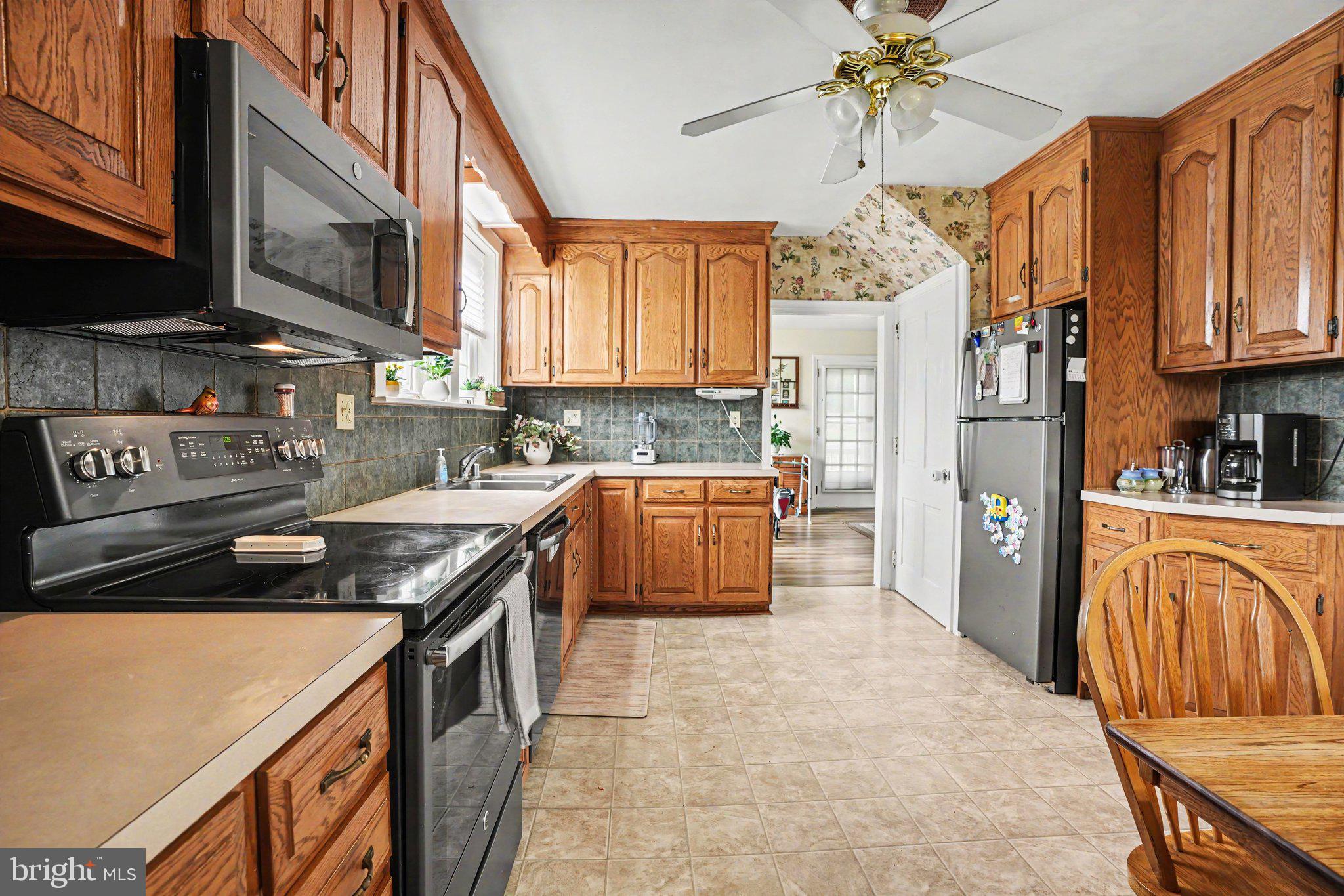 420 Carlisle Road Biglerville, PA 17307 - Photo 9 of 41 a kitchen with stainless steel appliances granite countertop a refrigerator a stove top oven a sink dishwasher and wooden cabinets