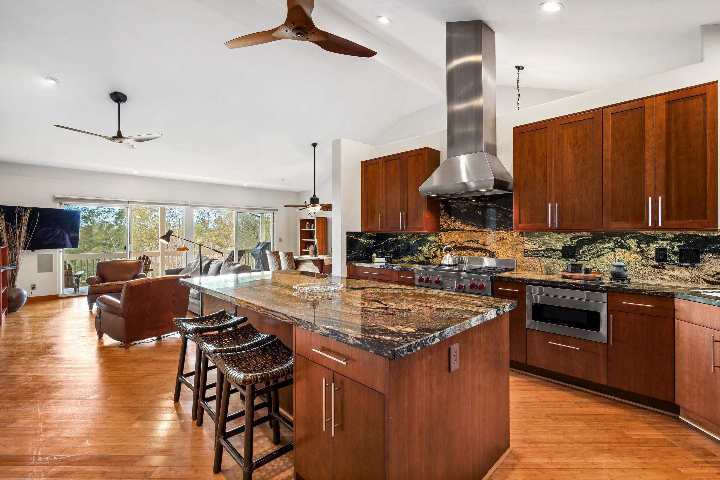 a kitchen with stainless steel appliances granite countertop a stove a sink dishwasher and a refrigerator with wooden floor