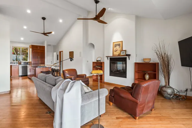 a living room with furniture a flat screen tv and kitchen view