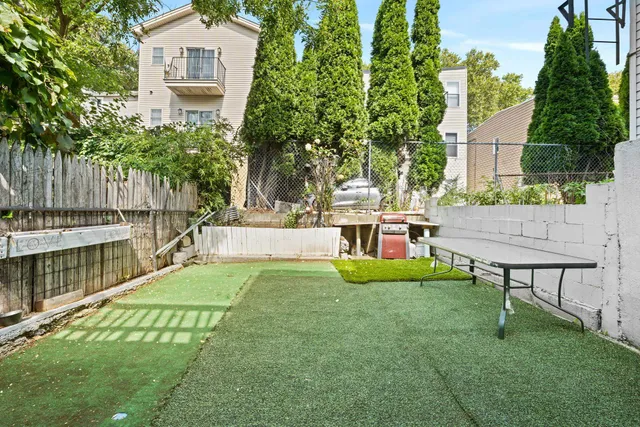 a view of house with backyard and sitting area