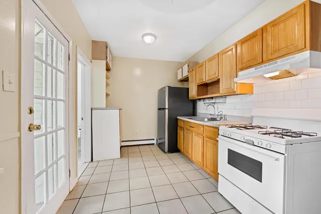 a kitchen with a stove a refrigerator and a cabinets