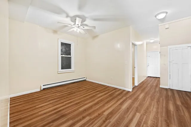a view of an empty room with wooden floor