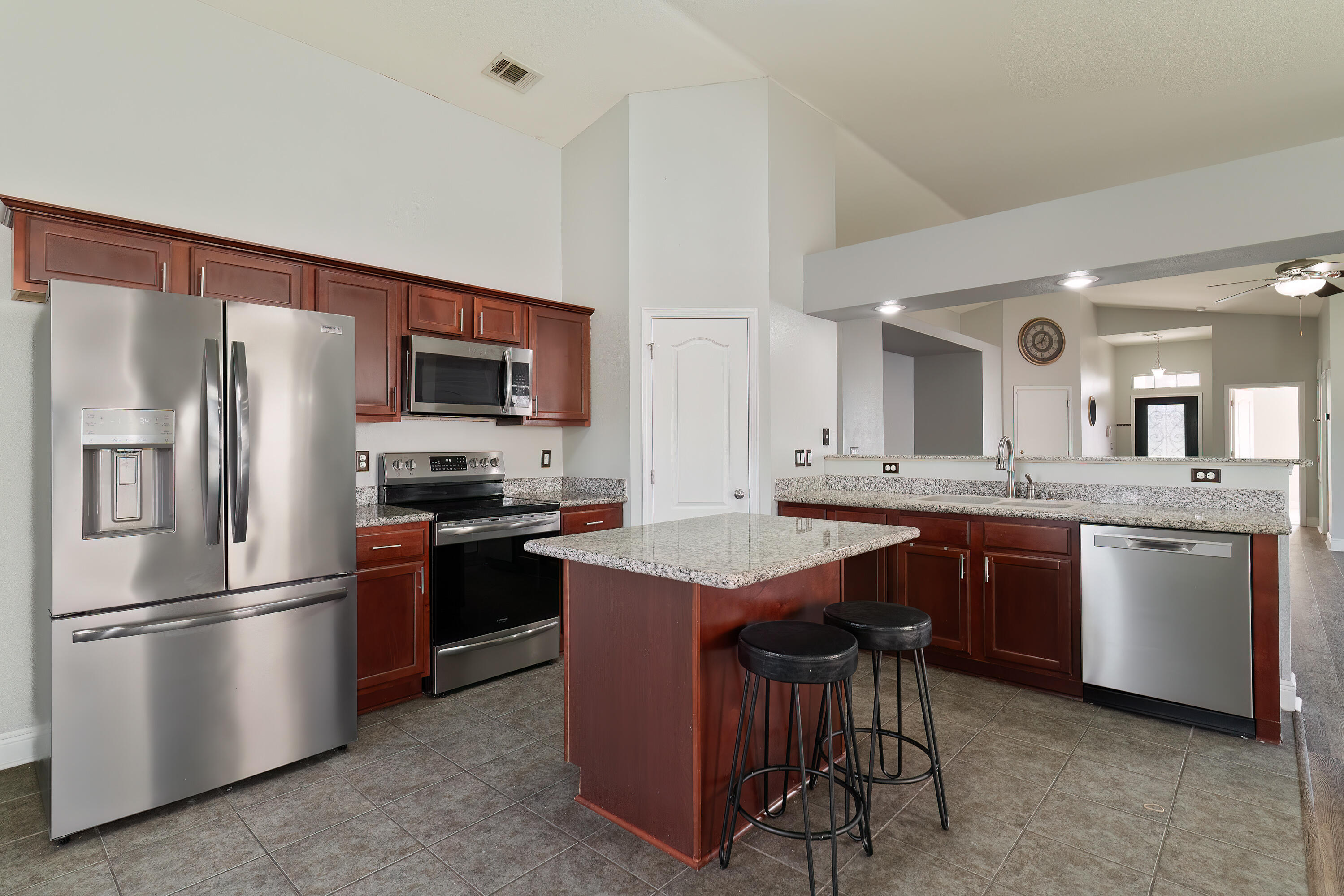 4633 Hermosa Road Crestview, FL 32539 - Photo 18 of 53 a kitchen with stainless steel appliances granite countertop a refrigerator a sink a stove a dining table and chairs