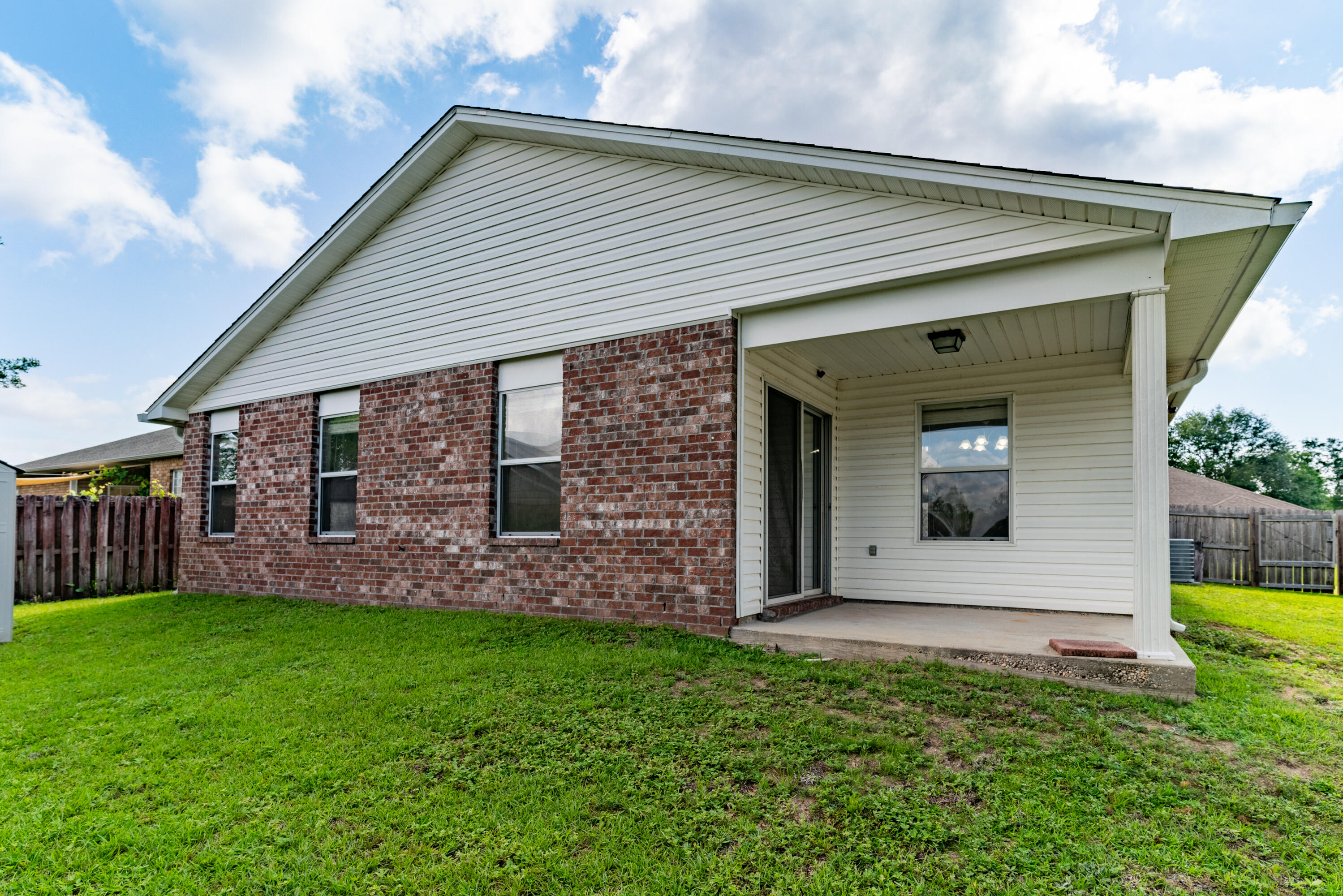 4633 Hermosa Road Crestview, FL 32539 - Photo 47 of 53 a view of a house with brick walls and a yard with a large tree