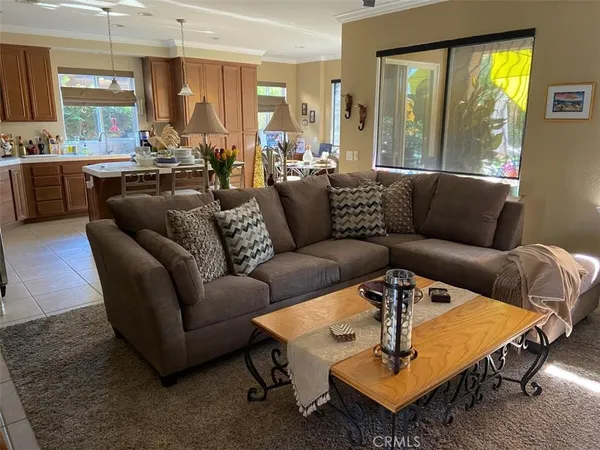a living room with furniture wooden floor and a large window