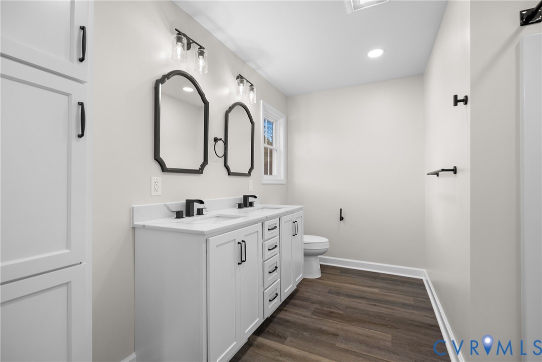 1373 Twenty Two Road Pamplin, VA 23958 - Photo 21 of 39 a bathroom with a double vanity sink toilet and a mirror