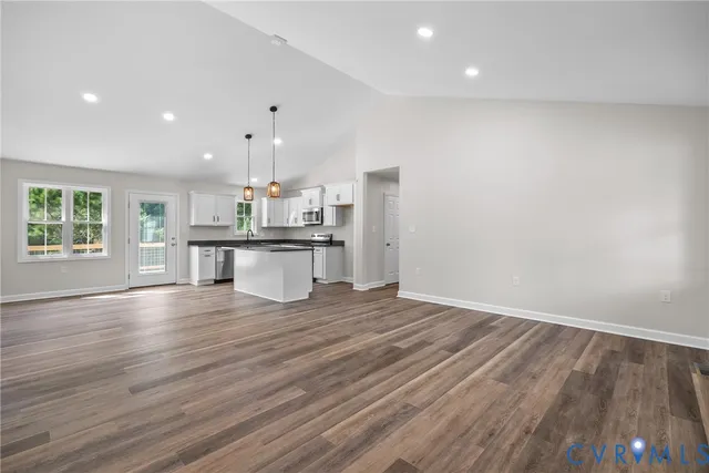 a kitchen with stainless steel appliances wooden floor and large windows