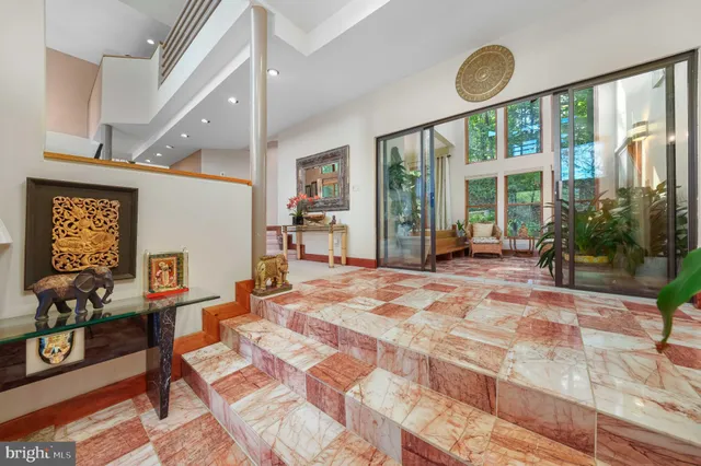 a living room with furniture a large window and wooden floor