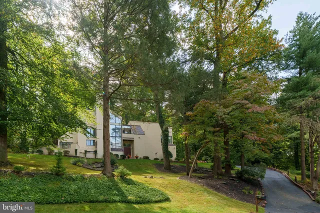 a front view of a house with a yard and trees