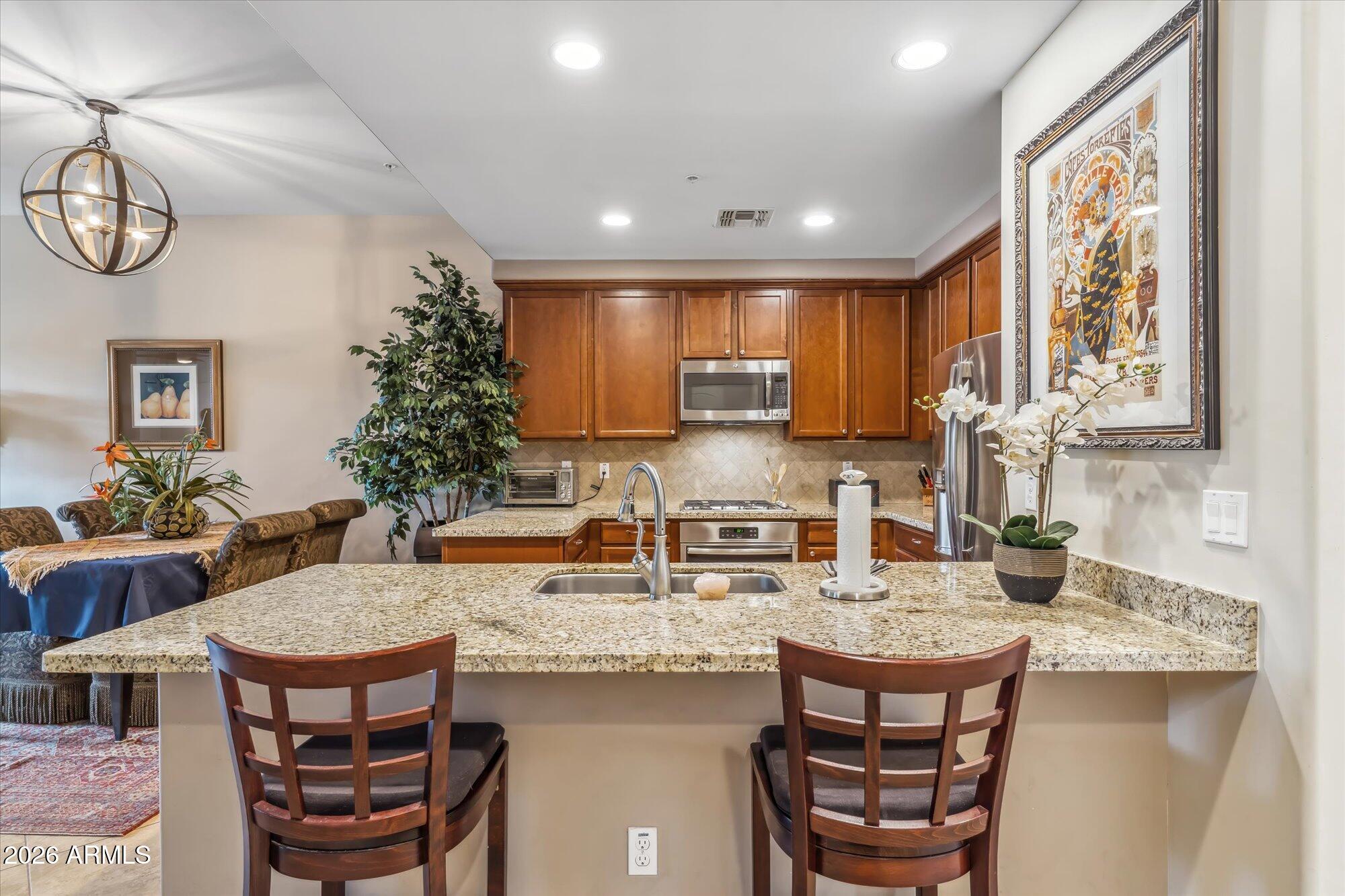 36600 North Cave Creek Road, Unit D11 Cave Creek, AZ 85331 - Photo 11 of 28 a kitchen with stainless steel appliances granite countertop a kitchen island a table and chairs in it