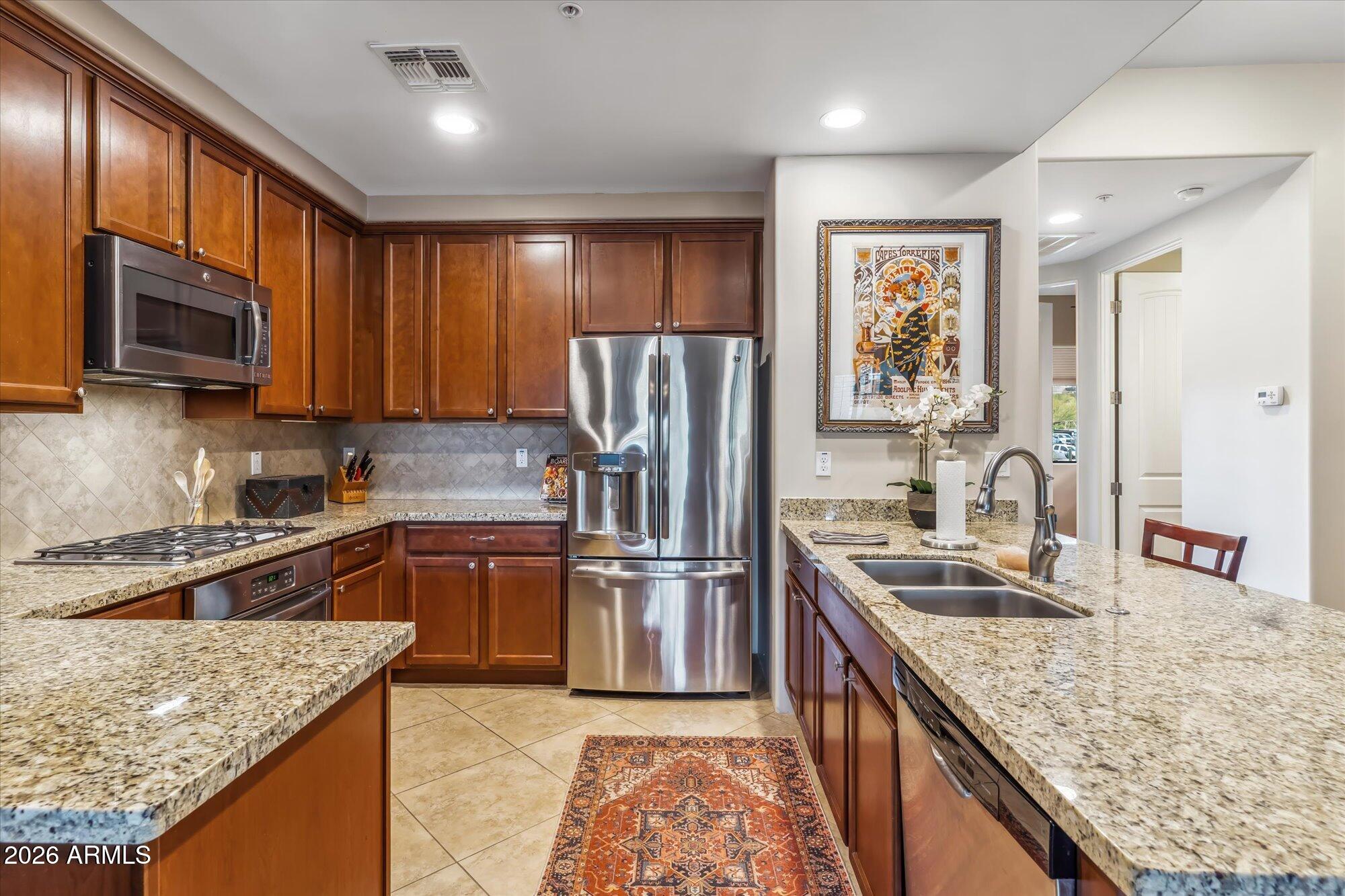 36600 North Cave Creek Road, Unit D11 Cave Creek, AZ 85331 - Photo 9 of 28 a kitchen with stainless steel appliances granite countertop a refrigerator stove microwave and sink