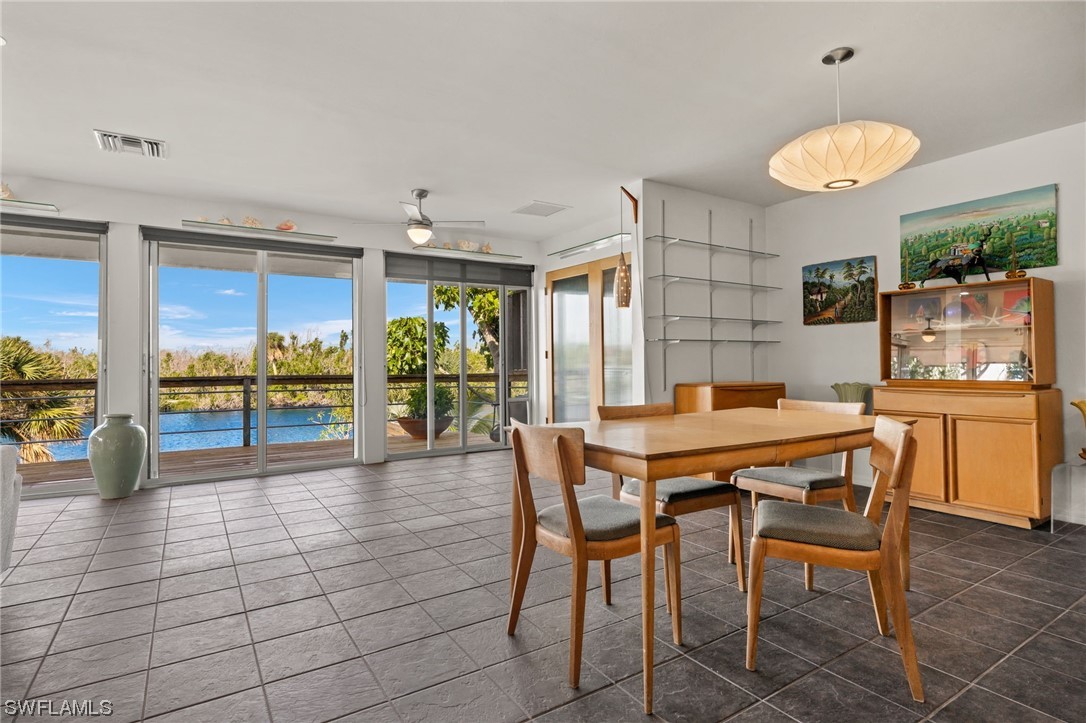 771 Rabbit Road Sanibel, FL 33957 - Photo 12 of 39 a dining hall with stainless steel appliances kitchen island granite countertop a table and chairs in it