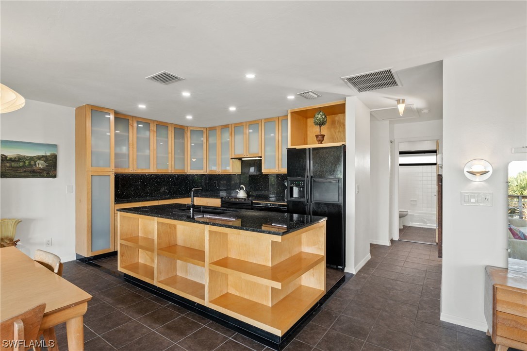 771 Rabbit Road Sanibel, FL 33957 - Photo 9 of 39 a kitchen with stainless steel appliances granite countertop a sink and a refrigerator