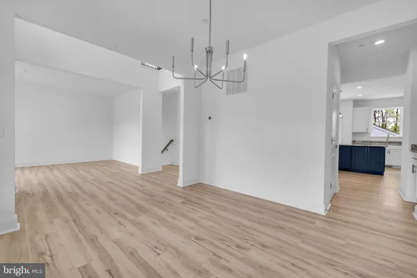 a view of a livingroom with wooden floor and kitchen view