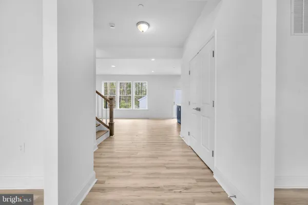 a view of a hallway with wooden floor and windows