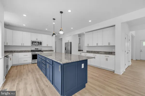 a kitchen with kitchen island granite countertop a sink and cabinets