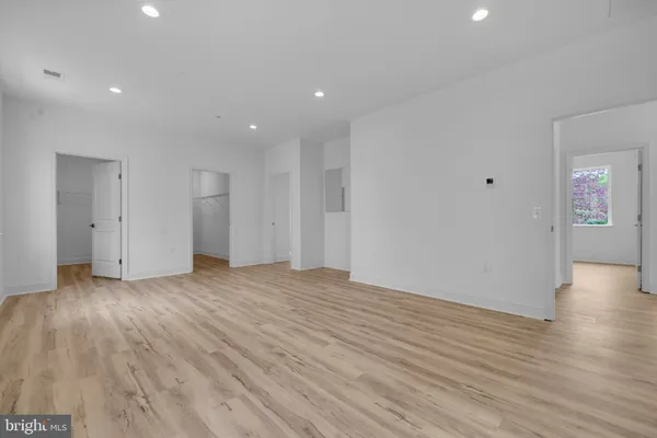 a view of a room with wooden floor and fan