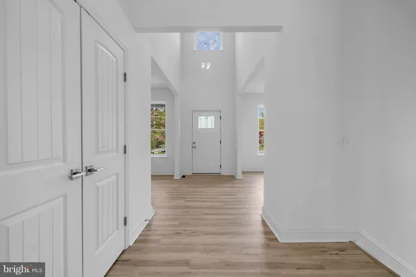a view of a hallway with wooden floor and closet area